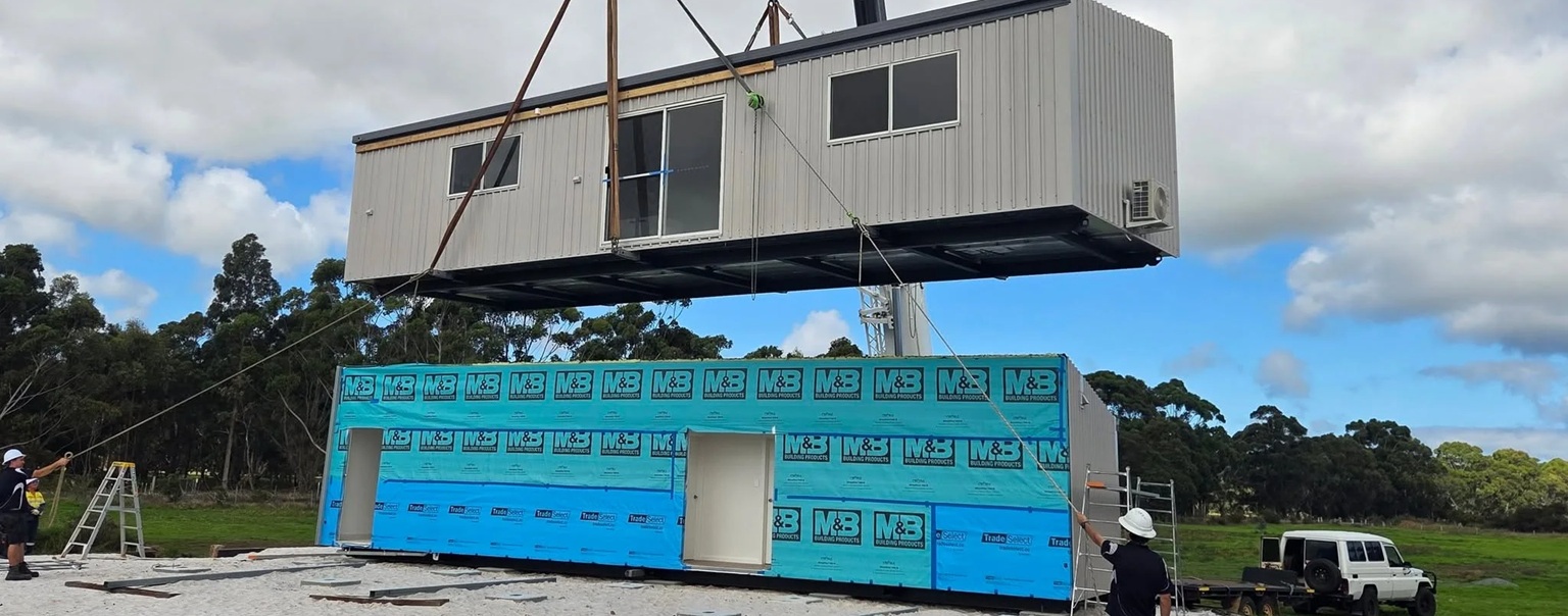 3 - Transportable granny flat being loaded onto a plot with a crane